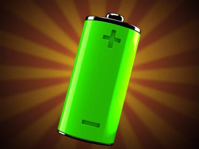 Groene batterij icoon met glans en stralen op achtergrond.