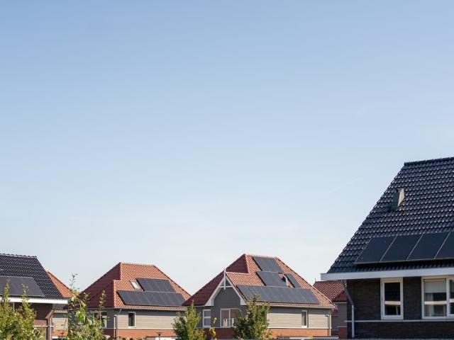 Woonwijk met huizen voorzien van zonnepanelen op de daken
